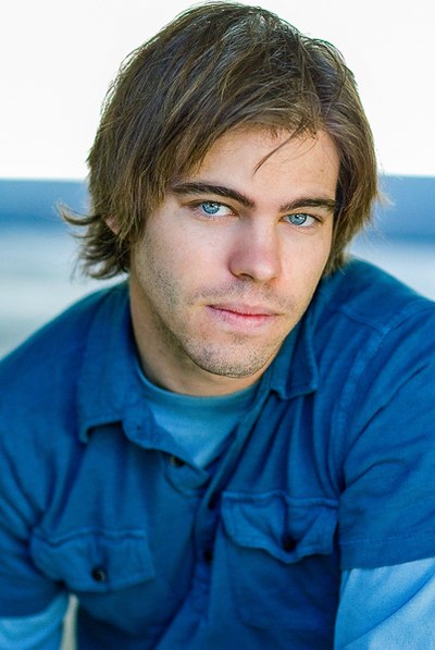 Person with side-swept hair and a blue shirt looking toward the camera.